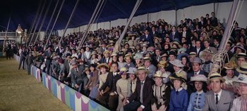 Movie still from “Circus World” (1964), directed by Henry Hathaway – A group of people sitting in a stadium with hats on; Wide shot, High angle