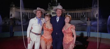 Movie still from “Circus World” (1964), directed by Henry Hathaway – A group of people standing next to each other wearing cowboy hats; Medium shot, Low angle