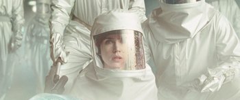 Movie still from “The Day the Earth Stood Still” (2008), directed by Scott Derrickson – A woman wearing a white suit and a face shield; Close Up shot, Overhead angle