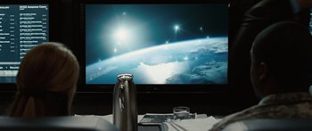 Movie still from “The Day the Earth Stood Still” (2008), directed by Scott Derrickson – A coffee pot sitting on top of a table in front of a television; Medium shot, Over the shoulder angle