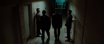 Movie still from “The Day the Earth Stood Still” (2008), directed by Scott Derrickson – A group of men standing in a dark hallway; Wide shot, High angle