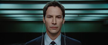 Movie still from “The Day the Earth Stood Still” (2008), directed by Scott Derrickson – A man in a suit and tie with a pair of ear phones; Close Up shot, Overhead angle