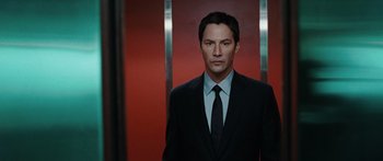 Movie still from “The Day the Earth Stood Still” (2008), directed by Scott Derrickson – A man wearing a suit and tie standing in front of a red wall; Medium shot, Low angle