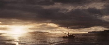 Movie still from “The Day the Earth Stood Still” (2008), directed by Scott Derrickson – A fishing boat in the ocean under a cloudy sky at sunset; Extreme Wide shot, Low angle