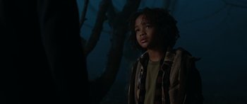 Movie still from “The Day the Earth Stood Still” (2008), directed by Scott Derrickson – A young boy standing in front of a tree in the dark; Medium shot, Low angle