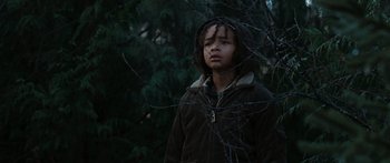 Movie still from “The Day the Earth Stood Still” (2008), directed by Scott Derrickson – A young boy wearing a brown jacket standing next to a tree; Medium shot, Low angle