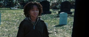 Movie still from “The Day the Earth Stood Still” (2008), directed by Scott Derrickson – A young girl is standing in a cemetery; Close Up shot, Over the shoulder angle