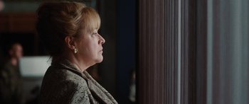 An older woman looking out of a window
