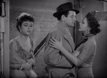 Movie still from “City That Never Sleeps” (1953), directed by John H. Auer – A man and two women in a black and white photo; Medium shot, Over the shoulder angle