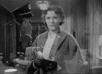 Movie still from “City That Never Sleeps” (1953), directed by John H. Auer – An old black and white photo of a woman and a police officer; Medium shot, Low angle