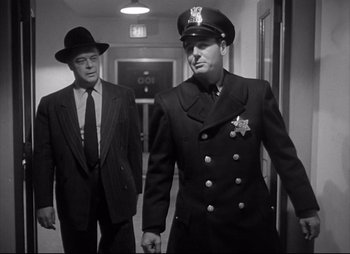 Movie still from “City That Never Sleeps” (1953), directed by John H. Auer – Two men in suits and hats walking in a hallway; Medium shot, Low angle