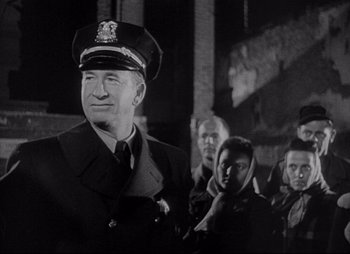 Movie still from “City That Never Sleeps” (1953), directed by John H. Auer – An old photo of a man in a military uniform; Medium shot, Low angle