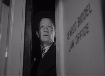 Movie still from “City That Never Sleeps” (1953), directed by John H. Auer – An older man standing in a door way; Medium shot, Low angle