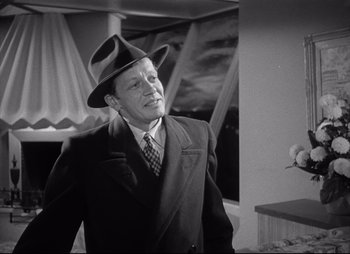 Movie still from “City That Never Sleeps” (1953), directed by John H. Auer – An older man wearing a suit and a hat; Medium shot, Low angle
