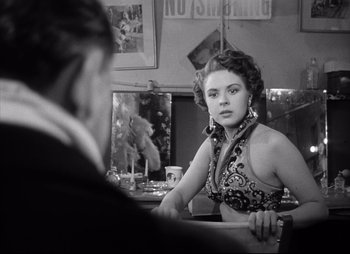 Movie still from “City That Never Sleeps” (1953), directed by John H. Auer – A woman sitting in front of a mirror in front of a man; Medium shot, Over the shoulder angle
