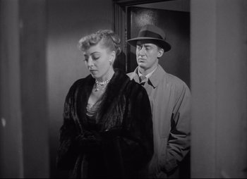 Movie still from “City That Never Sleeps” (1953), directed by John H. Auer – A man and a woman standing next to each other in front of an elevator; Medium shot, Low angle