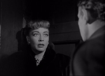 Movie still from “City That Never Sleeps” (1953), directed by John H. Auer – A black and white photo of a woman looking at a man in the mirror; Close Up shot, Over the shoulder angle