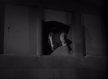 Movie still from “City That Never Sleeps” (1953), directed by John H. Auer – A person with an umbrella looking out a window; Medium shot, Low angle