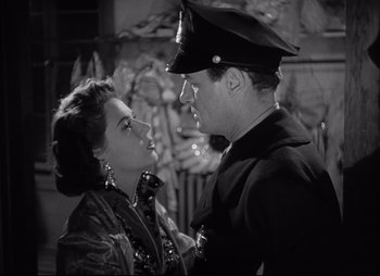 Movie still from “City That Never Sleeps” (1953), directed by John H. Auer – A man and a woman are looking at one another; Close Up shot, Low angle