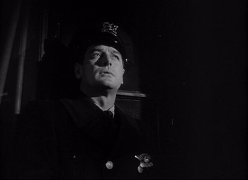 Movie still from “City That Never Sleeps” (1953), directed by John H. Auer – A man in a uniform is looking up at the sky; Close Up shot, Low angle