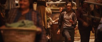 Movie still from “City of Ember” (2008), directed by Gil Kenan – A woman in a plaid shirt is walking through a crowd; Medium shot, Over the shoulder angle