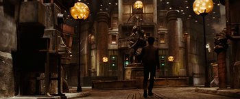 Movie still from “City of Ember” (2008), directed by Gil Kenan – A man is walking in front of a statue in a building; Extreme Wide shot, Low angle