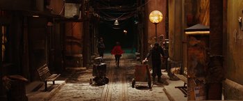 Movie still from “City of Ember” (2008), directed by Gil Kenan – A woman in a red coat walking down a street; Extreme Wide shot, High angle