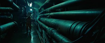 Movie still from “City of Ember” (2008), directed by Gil Kenan – A bunch of pipes that are next to each other in a room; Wide shot, Low angle