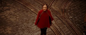 Movie still from “City of Ember” (2008), directed by Gil Kenan – A woman in a red coat standing on a brick road; Medium shot, High angle