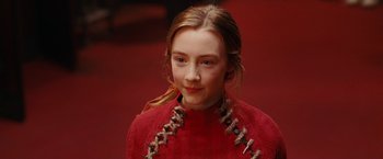 Movie still from “City of Ember” (2008), directed by Gil Kenan – A young girl in a red dress is smiling for the camera; Close Up shot, Over the shoulder angle