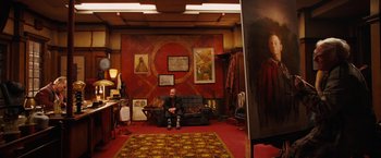 Movie still from “City of Ember” (2008), directed by Gil Kenan – A man sitting on top of a couch in a living room; Wide shot, Over the shoulder angle