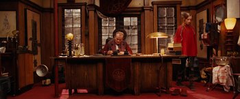 Movie still from “City of Ember” (2008), directed by Gil Kenan – An old man sitting at a desk looking at a phone; Wide shot, Low angle