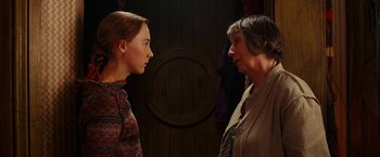 Movie still from “City of Ember” (2008), directed by Gil Kenan – Two women standing next to each other in front of a wooden door; Medium shot, Over the shoulder angle