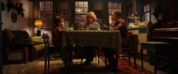 Movie still from “City of Ember” (2008), directed by Gil Kenan – A group of people sitting at a dinner table; Wide shot, High angle