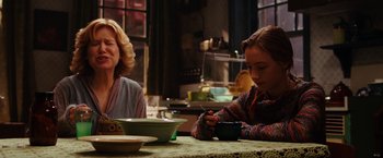 Movie still from “City of Ember” (2008), directed by Gil Kenan – Two people sitting at a table with a cup of coffee; Medium shot, Over the shoulder angle