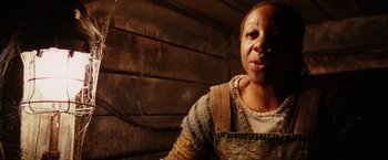 Movie still from “City of Ember” (2008), directed by Gil Kenan – An older woman wearing a sweater in front of a wooden wall; Close Up shot, Low angle
