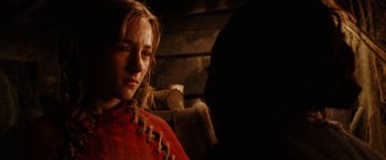 Movie still from “City of Ember” (2008), directed by Gil Kenan – A woman in a red dress is standing in a dark room; Close Up shot, Over the shoulder angle