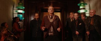 Movie still from “City of Ember” (2008), directed by Gil Kenan – A man wearing a suit and tie standing in front of two other men; Medium shot, Low angle
