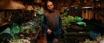 Movie still from “City of Ember” (2008), directed by Gil Kenan – A man in a costume standing in front of plants; Medium shot, Low angle