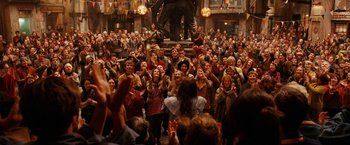 Movie still from “City of Ember” (2008), directed by Gil Kenan – A crowd of people standing around a statue of a man; Wide shot, Over the shoulder angle