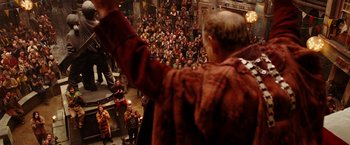 Movie still from “City of Ember” (2008), directed by Gil Kenan – A crowd of people standing around a building; Wide shot, Over the shoulder angle