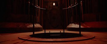 Movie still from “City of Ember” (2008), directed by Gil Kenan – A dark room with a circular stage in the center; Extreme Wide shot, Low angle