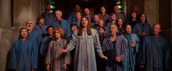Movie still from “City of Ember” (2008), directed by Gil Kenan – A group of people singing together in a choir room; Medium shot, Low angle
