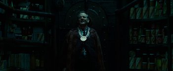 Movie still from “City of Ember” (2008), directed by Gil Kenan – A man wearing a necklace with a cross on it; Medium shot, Low angle