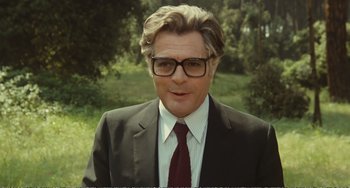 Movie still from “City of Women” (1980), directed by Federico Fellini – A person wearing a suit and tie; Medium shot, Over the shoulder angle