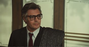 Movie still from “City of Women” (1980), directed by Federico Fellini – A person wearing a suit and glasses; Close Up shot, Over the shoulder angle
