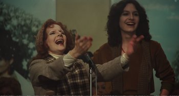 Movie still from “City of Women” (1980), directed by Federico Fellini – Two women standing next to each other on a stage; Medium shot, Low angle