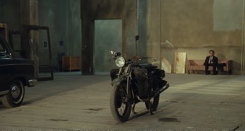 Movie still from “City of Women” (1980), directed by Federico Fellini – A motorcycle parked on the side of the street; Wide shot, High angle