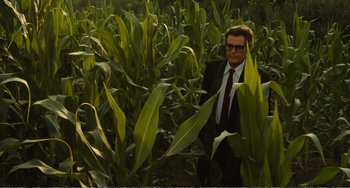 Movie still from “City of Women” (1980), directed by Federico Fellini – A man in a suit and tie standing in a corn field; Wide shot, High angle