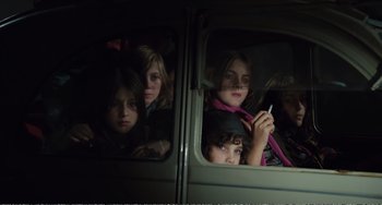 Movie still from “City of Women” (1980), directed by Federico Fellini – A group of children sitting in the back of a van; Medium shot, High angle